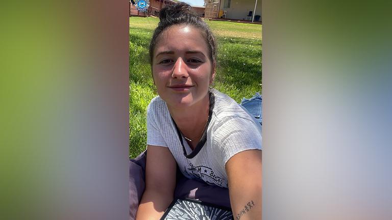 Die Deutsche Carolina Wilga macht ein Selfie, während sie auf einer Wiese liegt.
