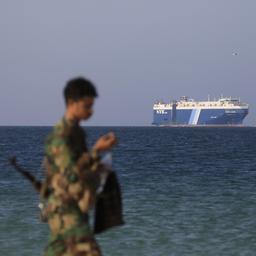 Ein Huthi-Mitglied geht am Strand entlang - mit dem Frachtschiff "Galaxy Leader" im Hintergrund.