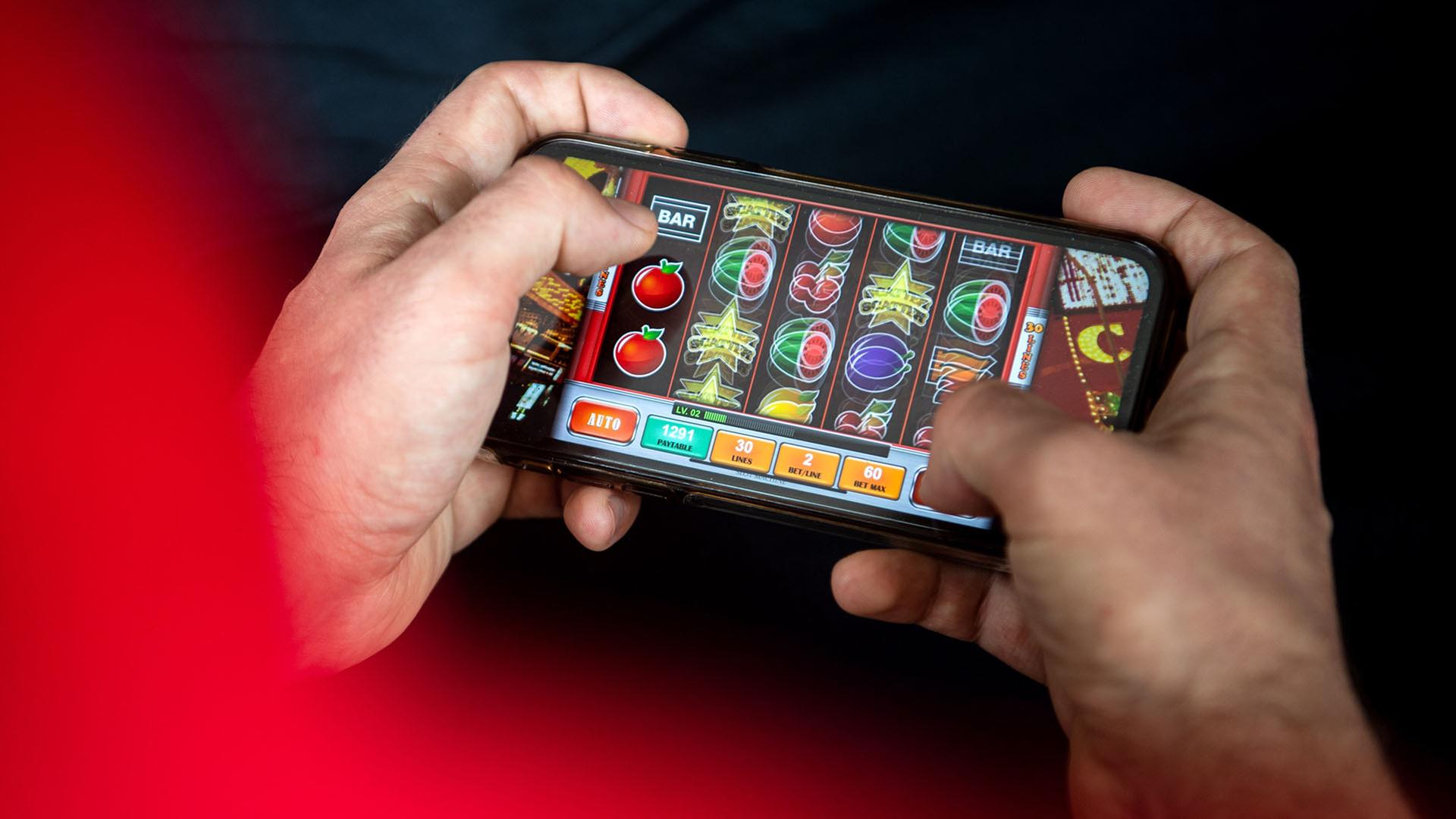 Ein Online-Glücksspiel wird auf einem Mobiltelefon gespielt. | picture alliance/dpa