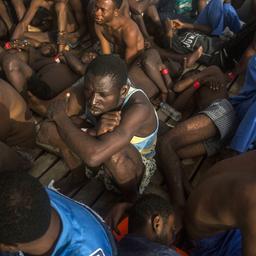Migranten sitzen zusammengedrängt an Bord eines Schiffes