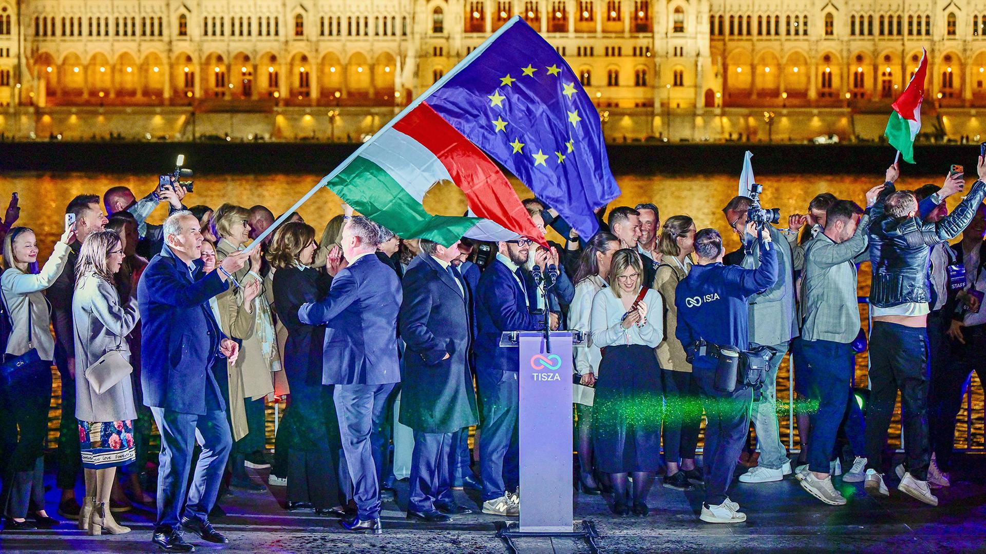 Fahnen werden geschwenkt, davor steht ein Rednerpult | REUTERS