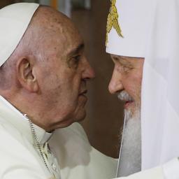 Papst Franziskus und Patriarch Kyrill umarmen einander.