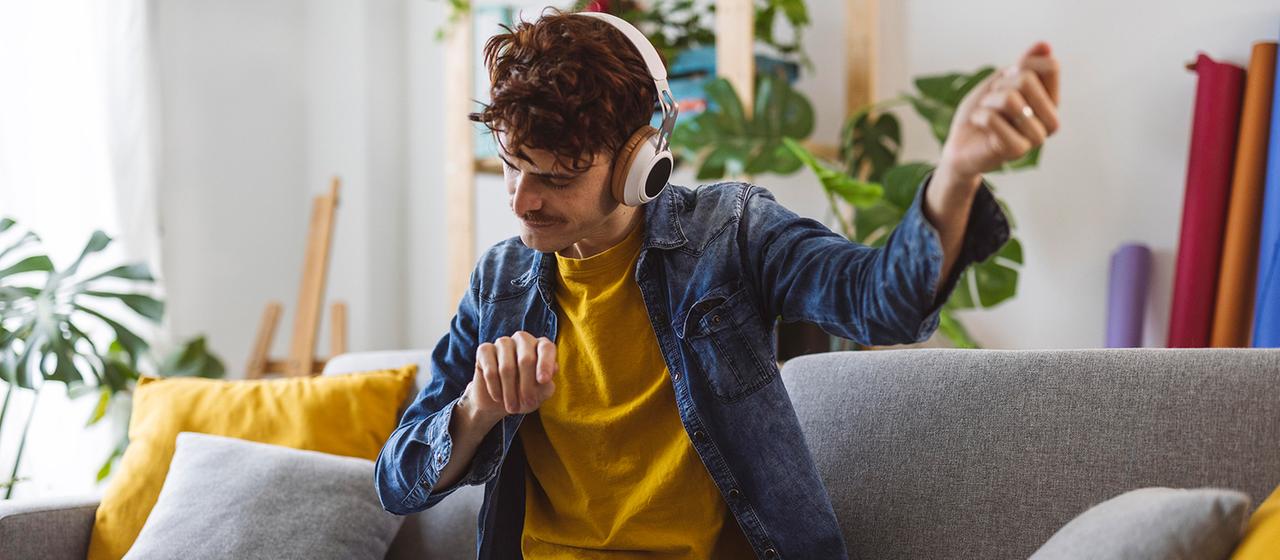 Ein junger Mann hört Musik mit Kopfhörern.