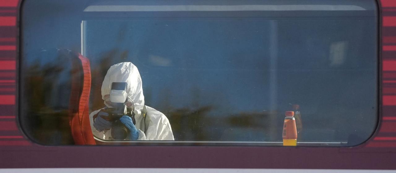 Ein Beamter sichert Spuren an dem Zug