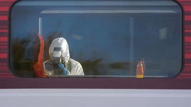 Ein Beamter sichert Spuren an dem Zug