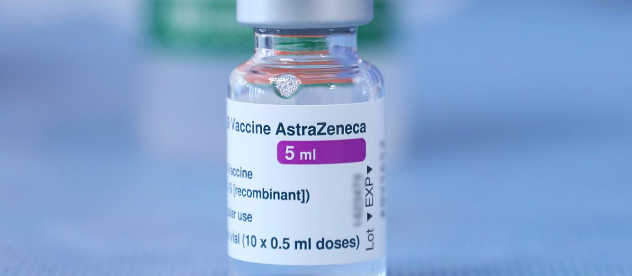 Ein Fläschchen mit einem Impfstoff von AstraZeneca ist auf einem Tisch zu sehen.