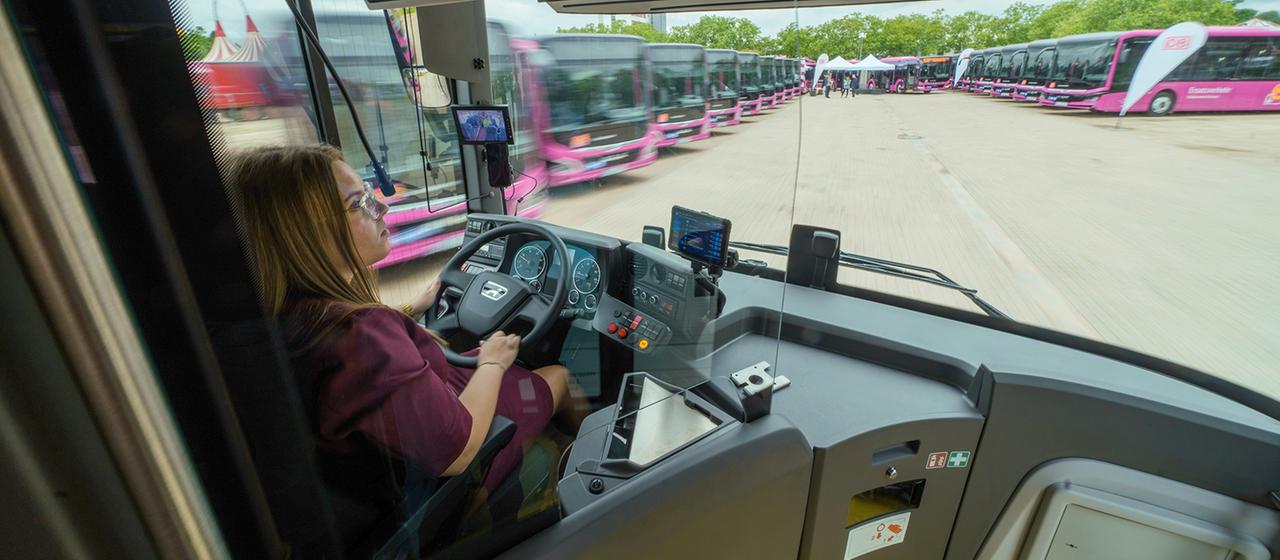 Eine busfahrerin fährt einen DB-Bus von MAN.