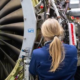Ein Mitarbeiterin arbeitet bei MTU Maintenance Berlin-Brandenburg an einem Antrieb.