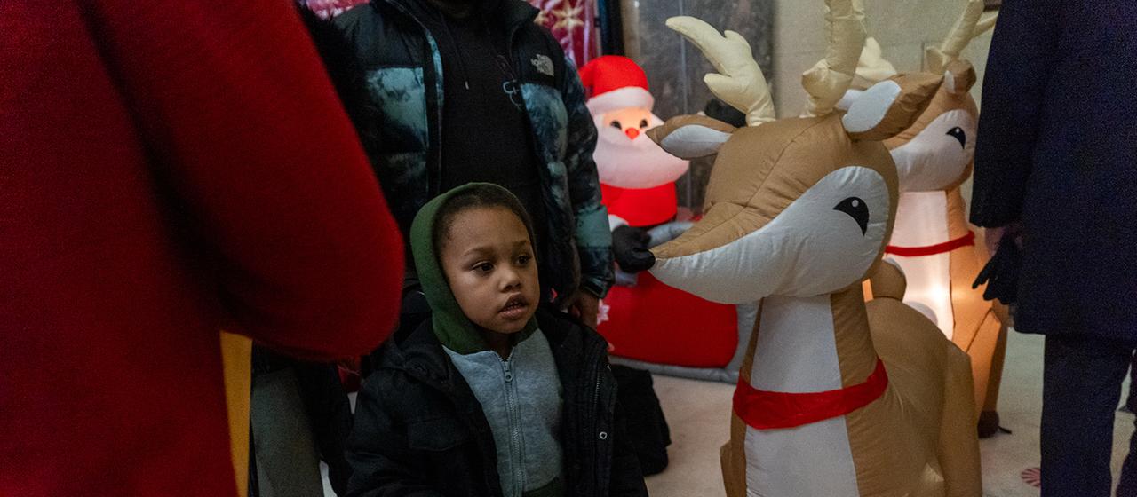 Ein Kind steht neben Weihnachtsdekoration im Stadtteil Bronx in New York.