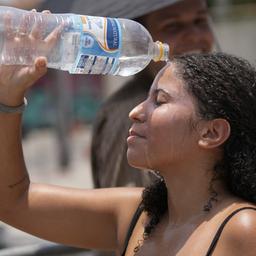 Eine Frau in Rio de Janeiro kühlt sich mit einer Wasserflasche ab. 