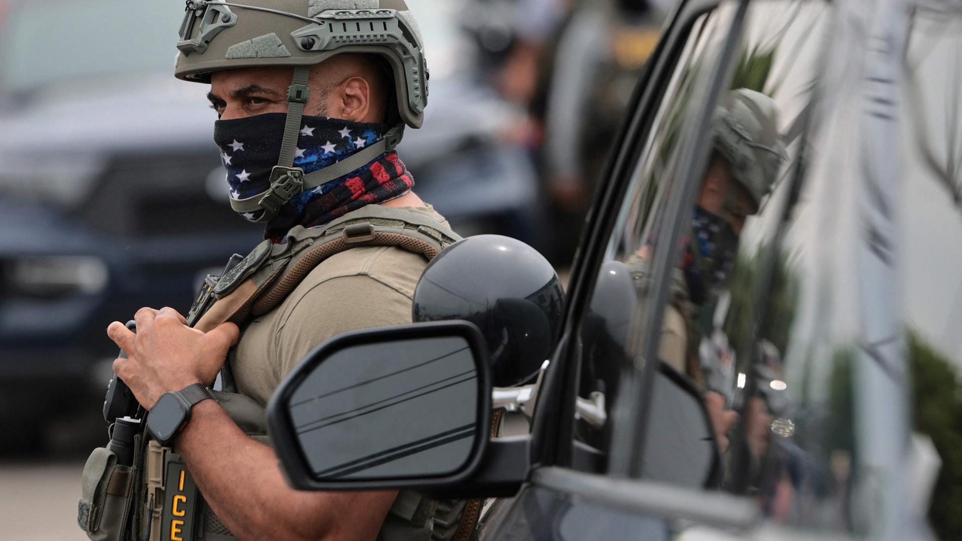 Ein Mitarbeiter der Einwanderungs- und Zollbehörde (ICE) lehnt an einem Auto in New Jersey. | Getty Images via AFP