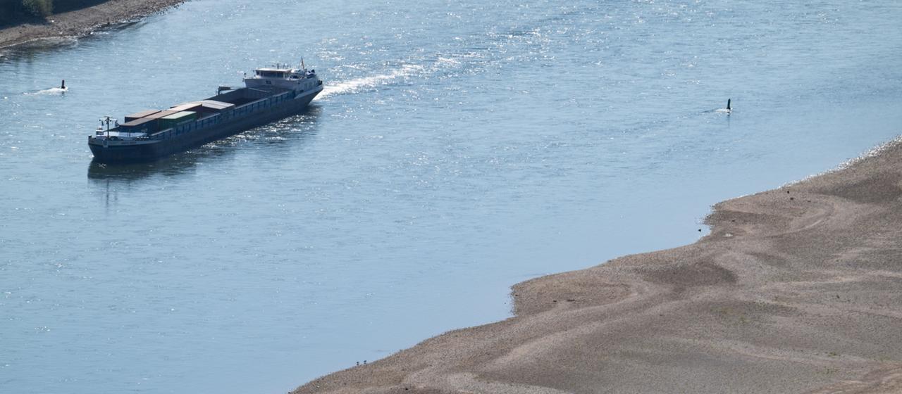Ein Schiff fährt an freiliegenden Sandbänken auf dem Rhein in  Bacharach.