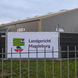 Gebäude hinter einem Zaun mit Banner, auf dem "Landgericht Magdeburg" steht
