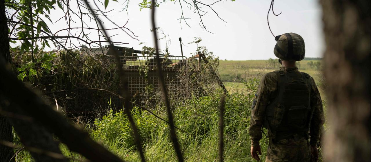 Ein ukrainischer Soldat beobachtet die Ankunft eines gepanzerten Fahrzeugs während eines Trainings.
