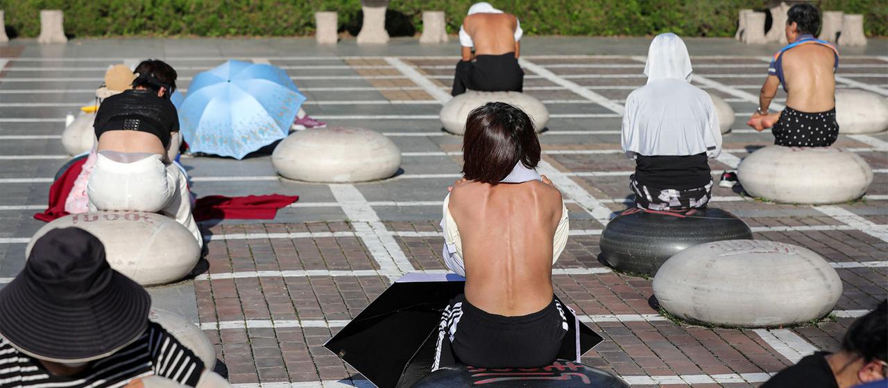 Menschen in China halten ihren Rücken in die Sonne.