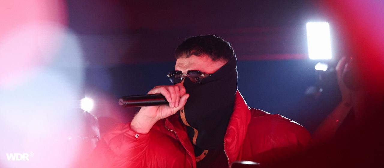 Rapper Aykut Anhan alias Haftbefehl mit Mikrofon bei einem Konzert im La Louve in Gießen.
