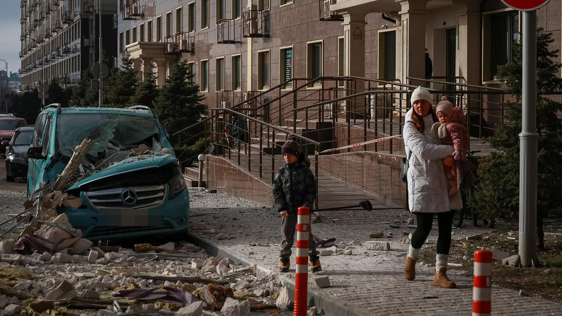 Eine Frau und Kinder gehen an Trümmern in Odessa vorbei. | REUTERS