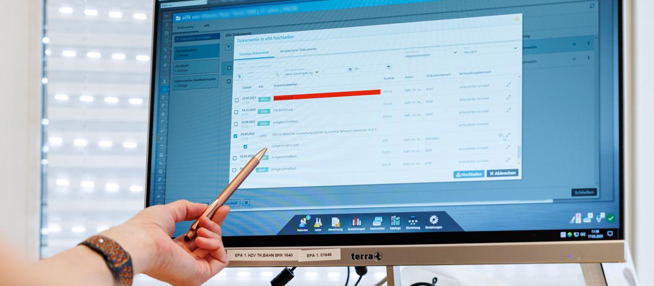 Ein Hausarzt lädt in seiner Praxis Dokumente in eine elektronische Patientenakte "ePA".