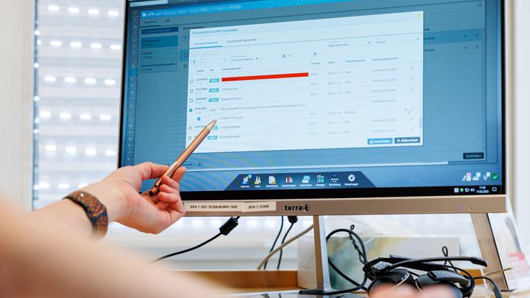 Ein Hausarzt lädt in seiner Praxis Dokumente in eine elektronische Patientenakte "ePA".