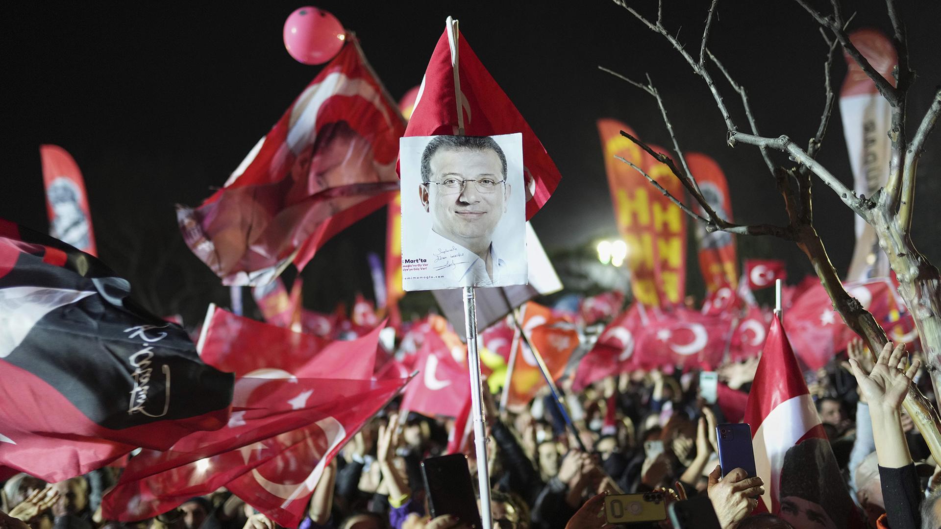 Demonstranten in Istanbul schwenken Fahnen und halten Bilder des festgenommenen Istanbuler Bürgermeisters Imamoglu hoch. (Archivbild: 25.03.2025) | dpa