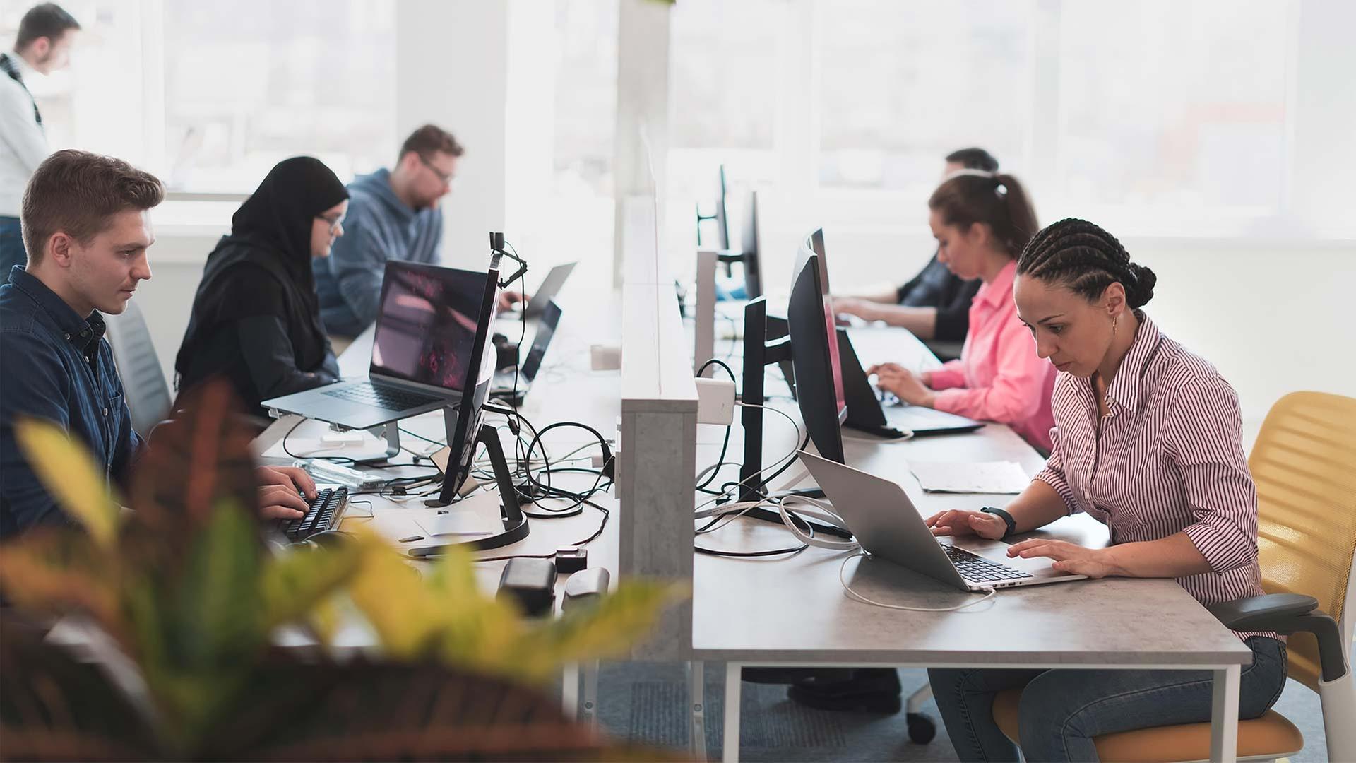 MÃ¤nner und Frauen bei der BÃ¼roarbeit. | picture alliance / Zoonar