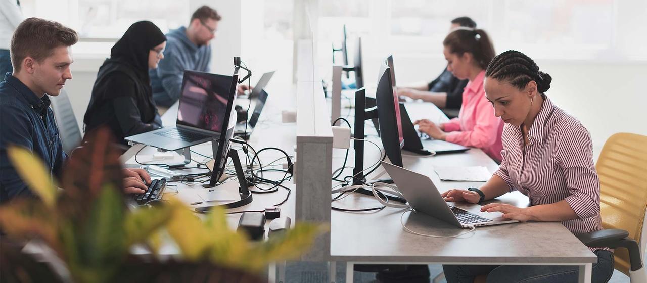 Männer und Frauen bei der Büroarbeit.
