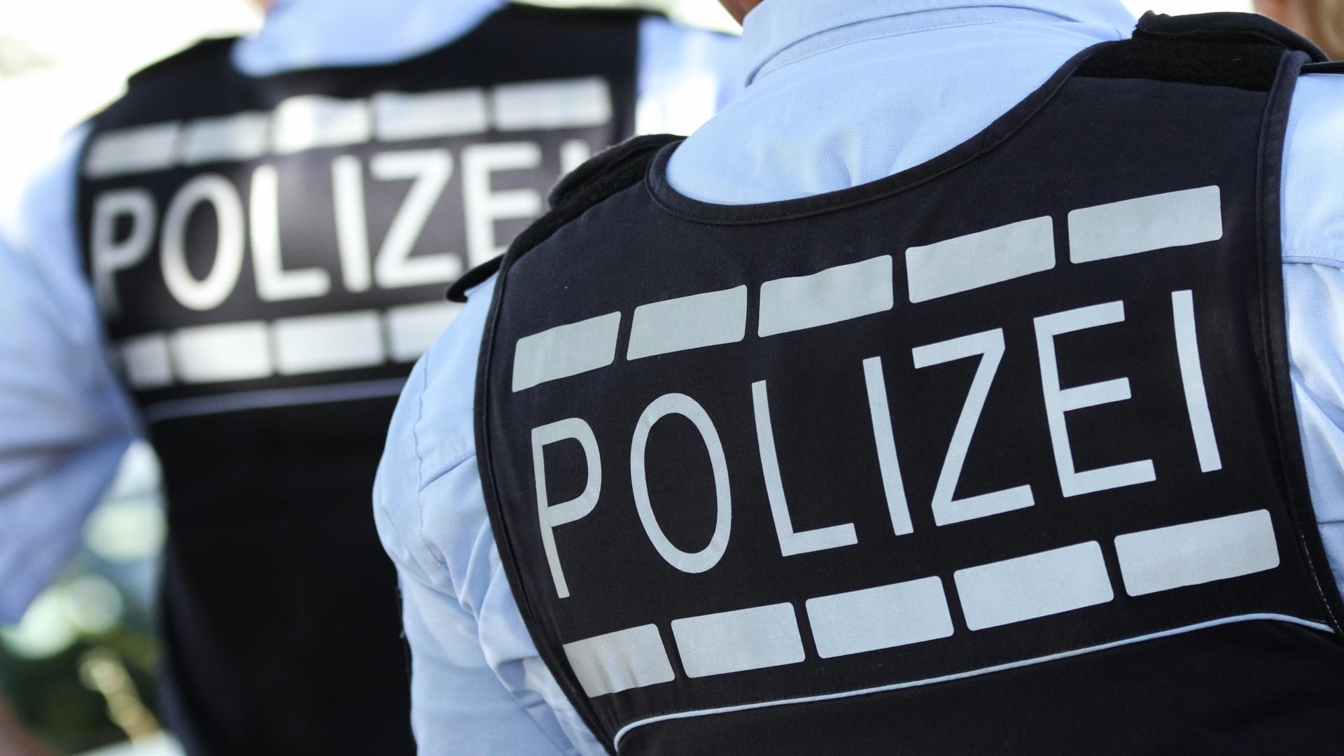 Ein Polizist von hinten mit einem Polizei-Schriftzug auf dem Rücken | dpa/Silas Stein