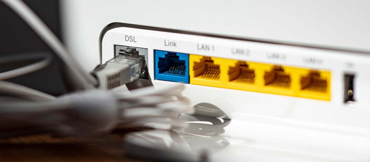 Ein LAN-Kabel steckt im DSL-Steckplatz eines WLAN-Routers.