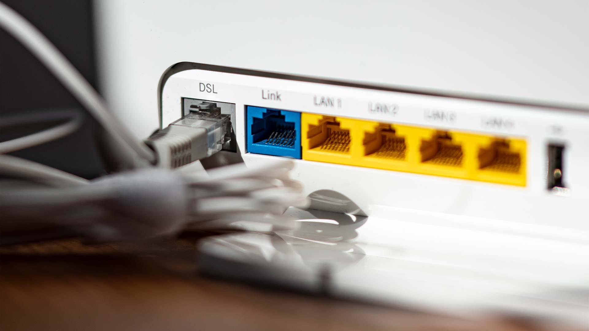 Ein LAN-Kabel steckt im DSL-Steckplatz eines WLAN-Routers. | picture alliance/dpa