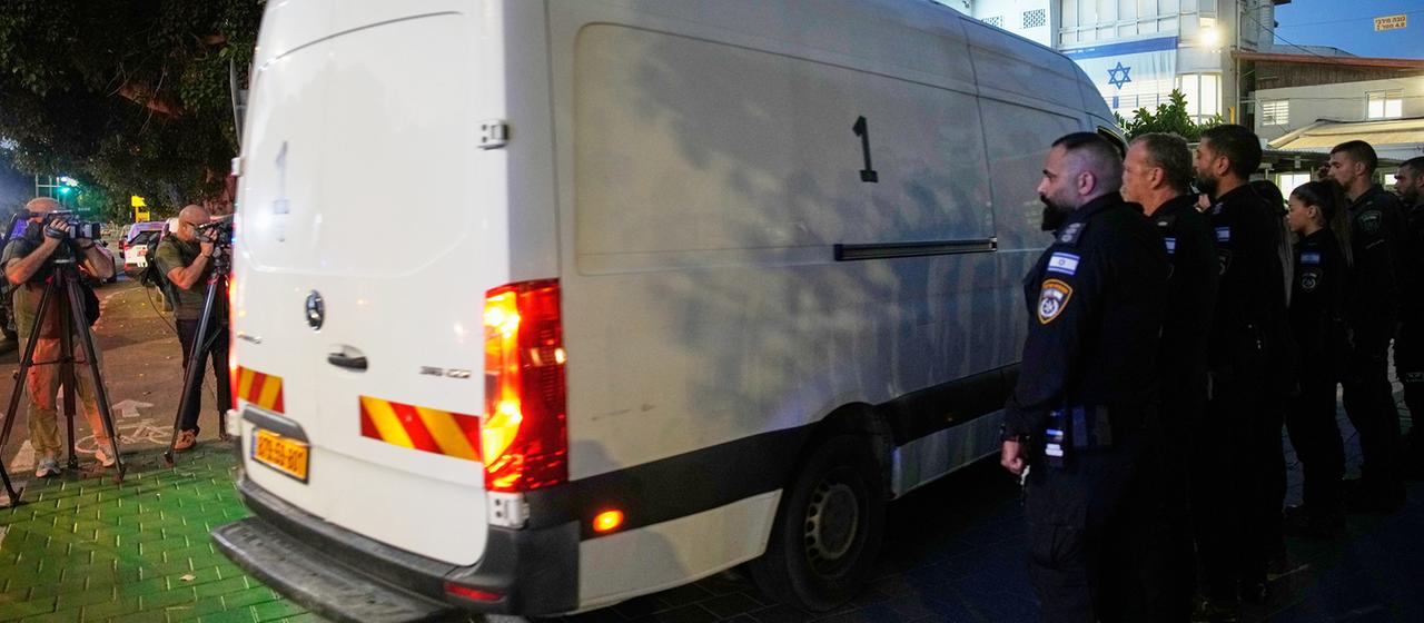 Ein Transporter fährt an Sicherheitskräften vorbei.