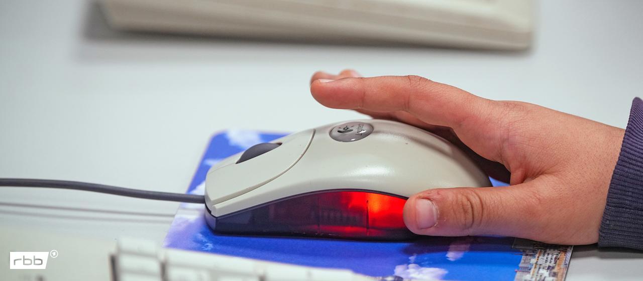 Symbolbild: Eine Hand bedient eine Maus am Computer (Quelle: picture alliance/dpa/S.Stache)