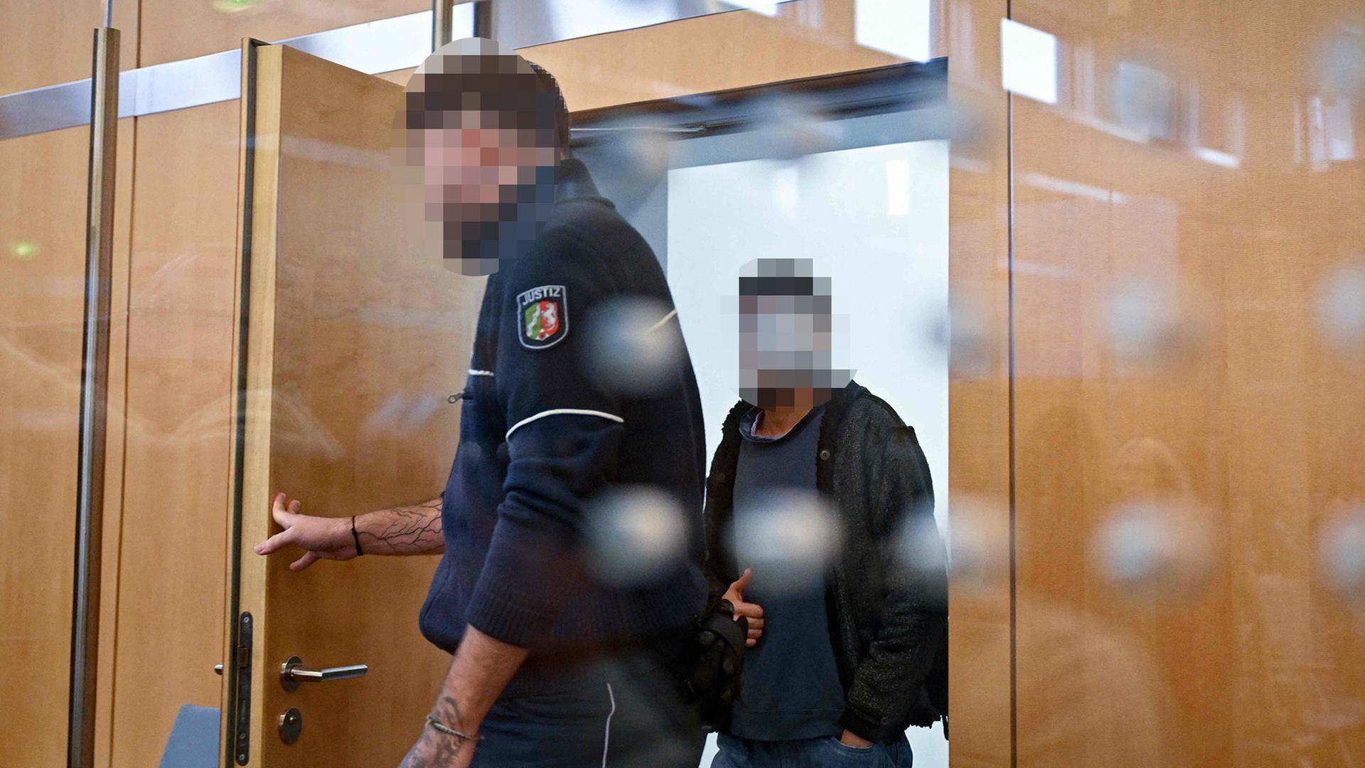 Ein Justizvollzugsbeamter und ein Angeklagter betreten einen Gerichtssaal. | AFP