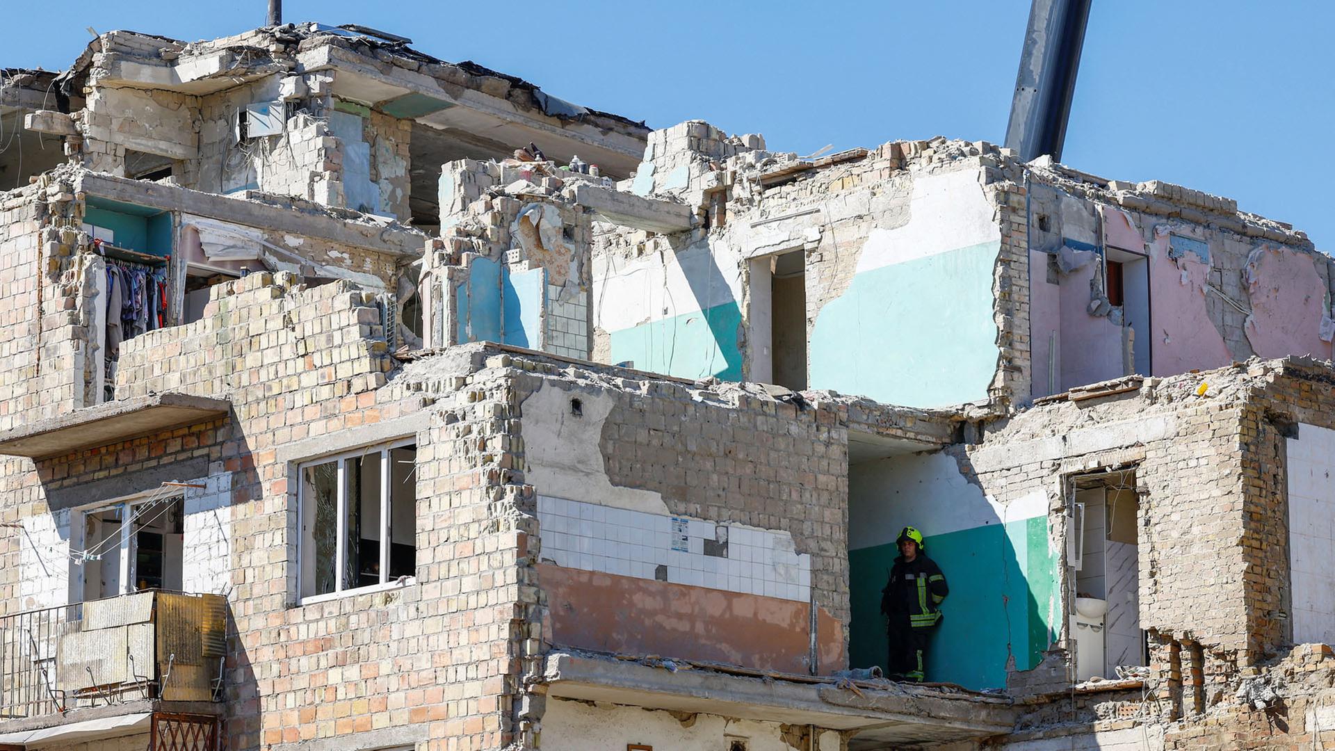 Ein Rettungshelfer steht in einem zerstörten Wohnhaus in Kiew, Ukraine. | REUTERS