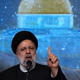 Ebrahim Raisi während einer Gedenkfeier für den verstorbenen Revolutionsgardengeneral Soleimani, der im Hintergrund auf einem Bildschirm zu sehen ist (aufgenommen am 3. Januar 2024)