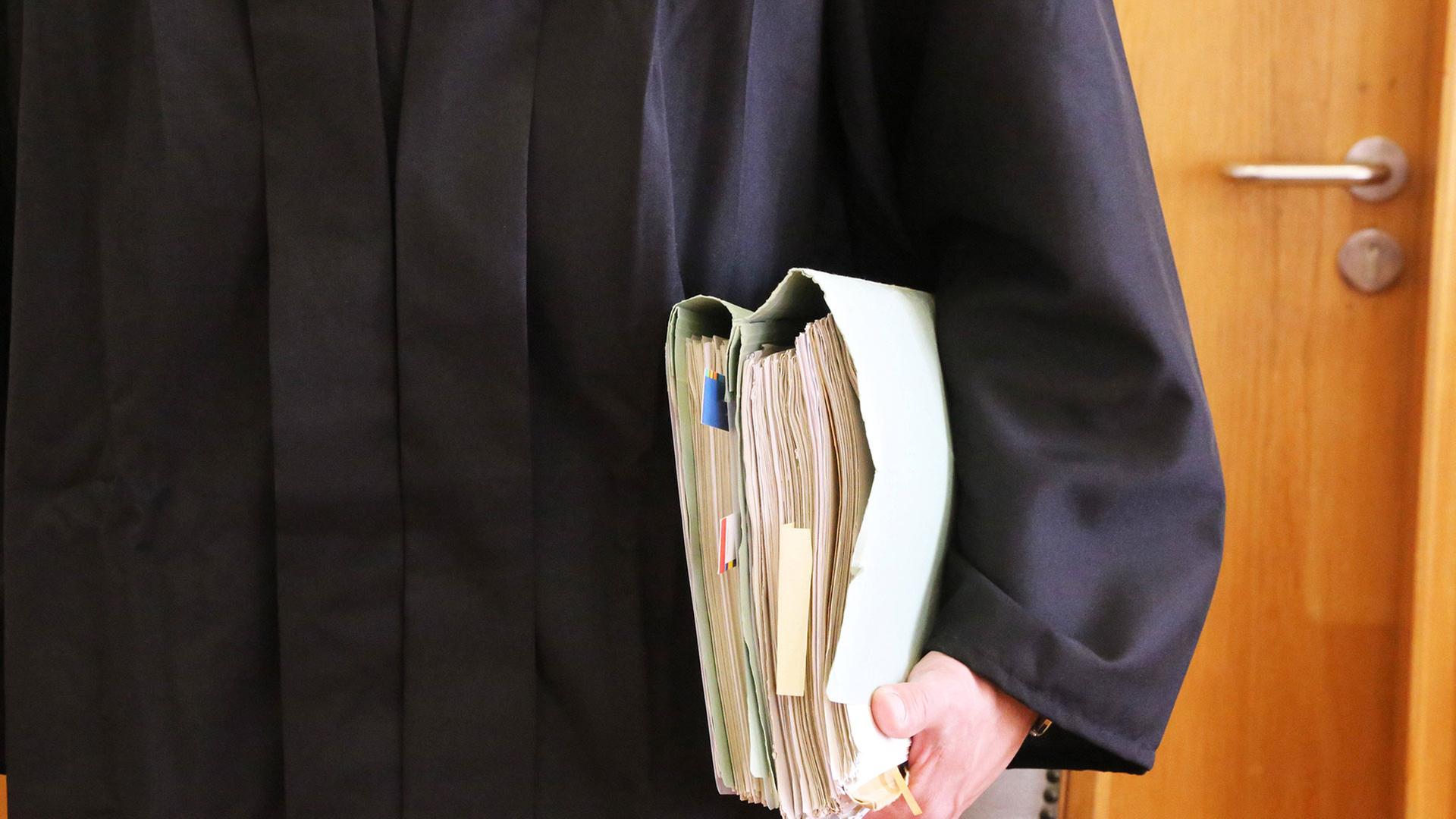 Ein Richter hält Akten in der Hand | IMAGO / Herrmann Agenturfotografie