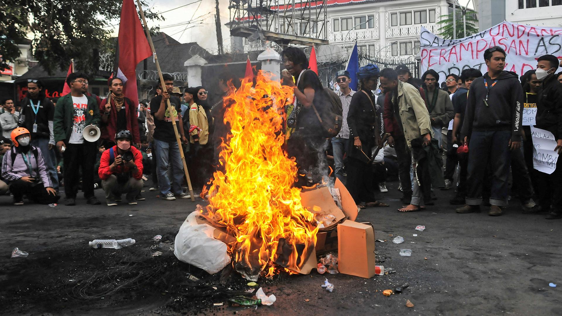 Demonstranten stehen neben einem Feuer in der Nähe des Regionalparlaments in Bandung (Indonesien). | REUTERS