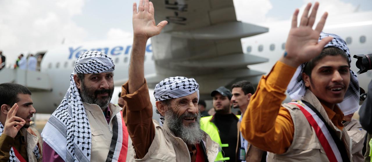  Huthi-Gefangene winken, während sie am Flughafen von Sanaa ankommen (Archivbild von 2023)