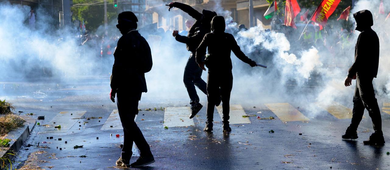 Demonstranten in Genf geraten inmitten von Tränengaswolken der Polizei.