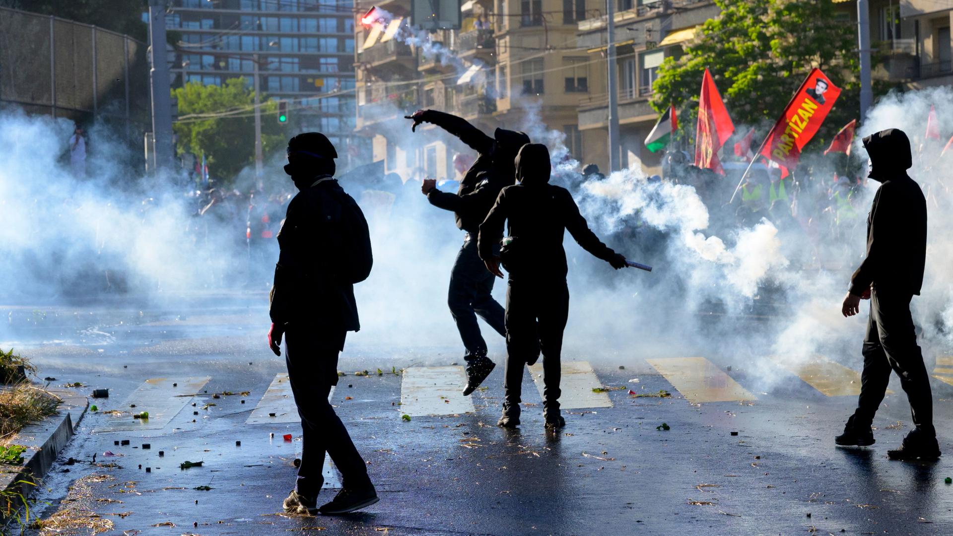 Demonstranten in Genf geraten inmitten von Tr�nengaswolken der Polizei. | dpa