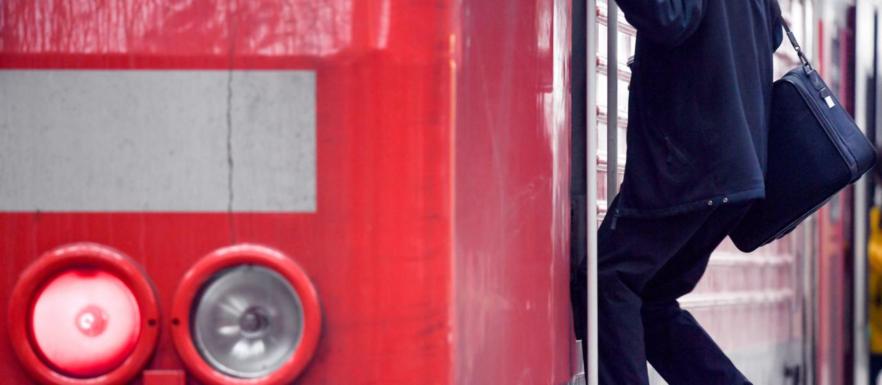 Ein Lokführer steigt aus einer Lokomotive der Deutschen Bahn.