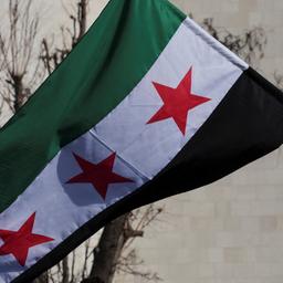 Ein Mann schwenkt eine von den neuen syrischen Machthabern angenommene Flagge in Damaskus, Syrien.