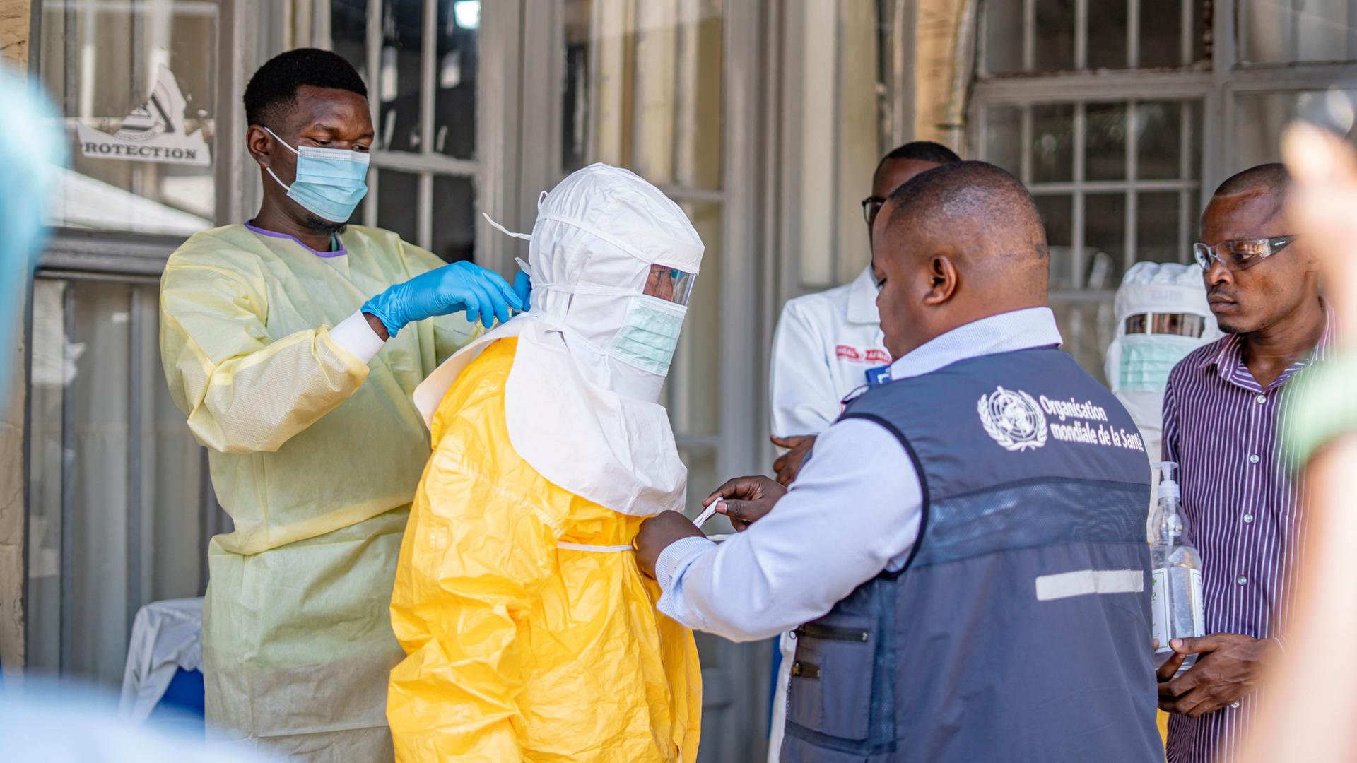  Ein medizinischer Mitarbeiter in DR Kongo zieht einen Schutzanzug an. | -/XinHua/dpa