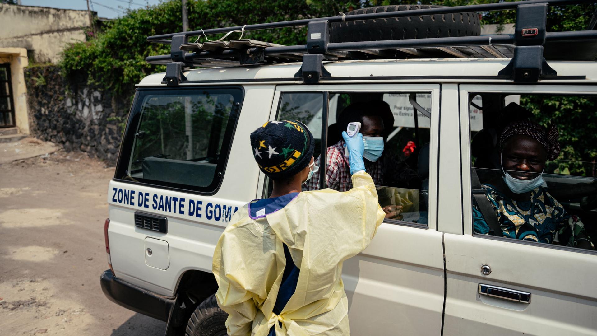 Ein Besucher l�sst sich von einem Gesundheitsmitarbeiter in Goma mit einem Thermoflash die Temperatur messen. | AFP