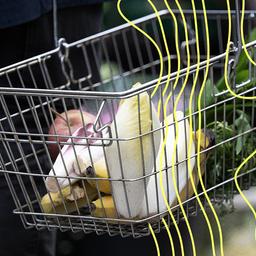 Ein Mann trägt auf einem Wochenmarkt seine Einkäufe in einem Korb.