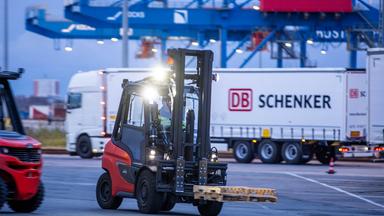 Paletten und Transportgut wird von Trailern des Logistikunternehmens DB Schenker auf dem Gelände des Logistikzentrums im Seehafen entladen.