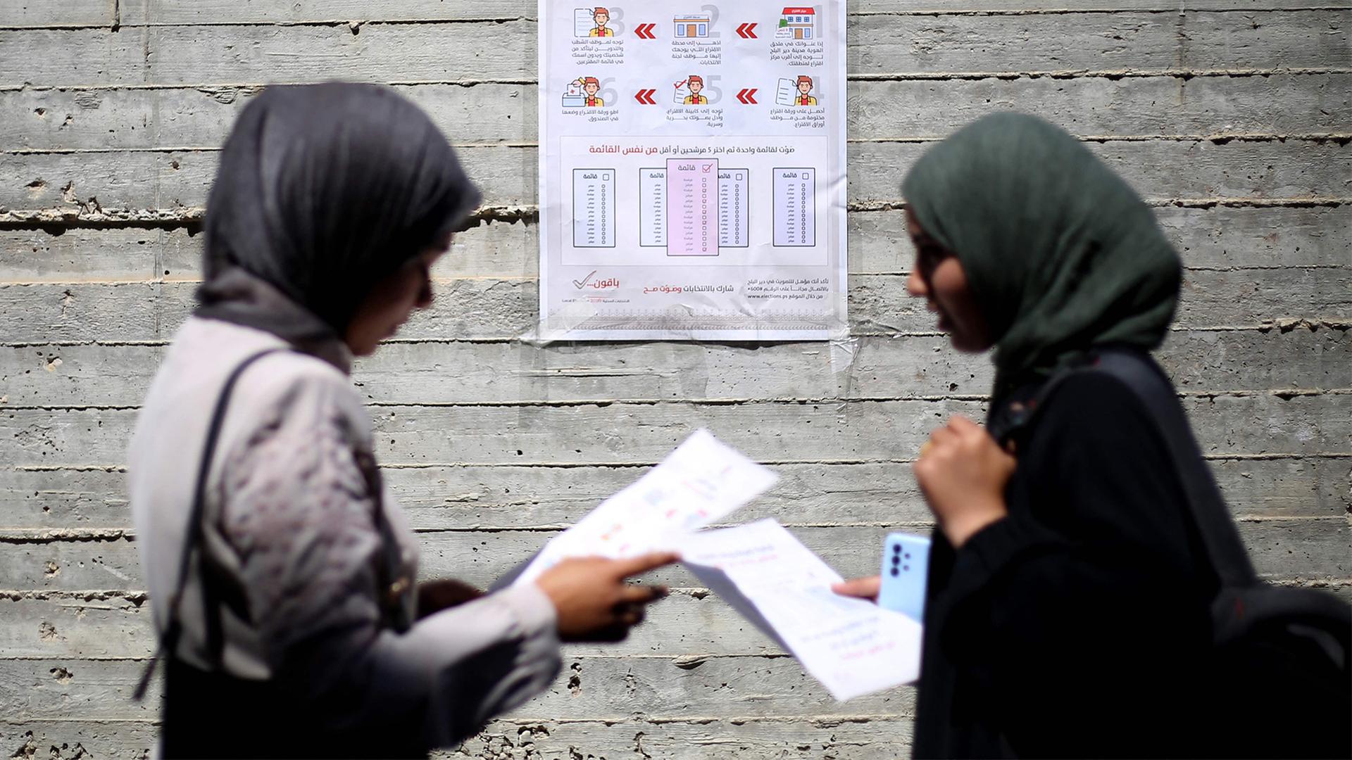 Zwei Frauen betrachten Unterlagen. | AFP