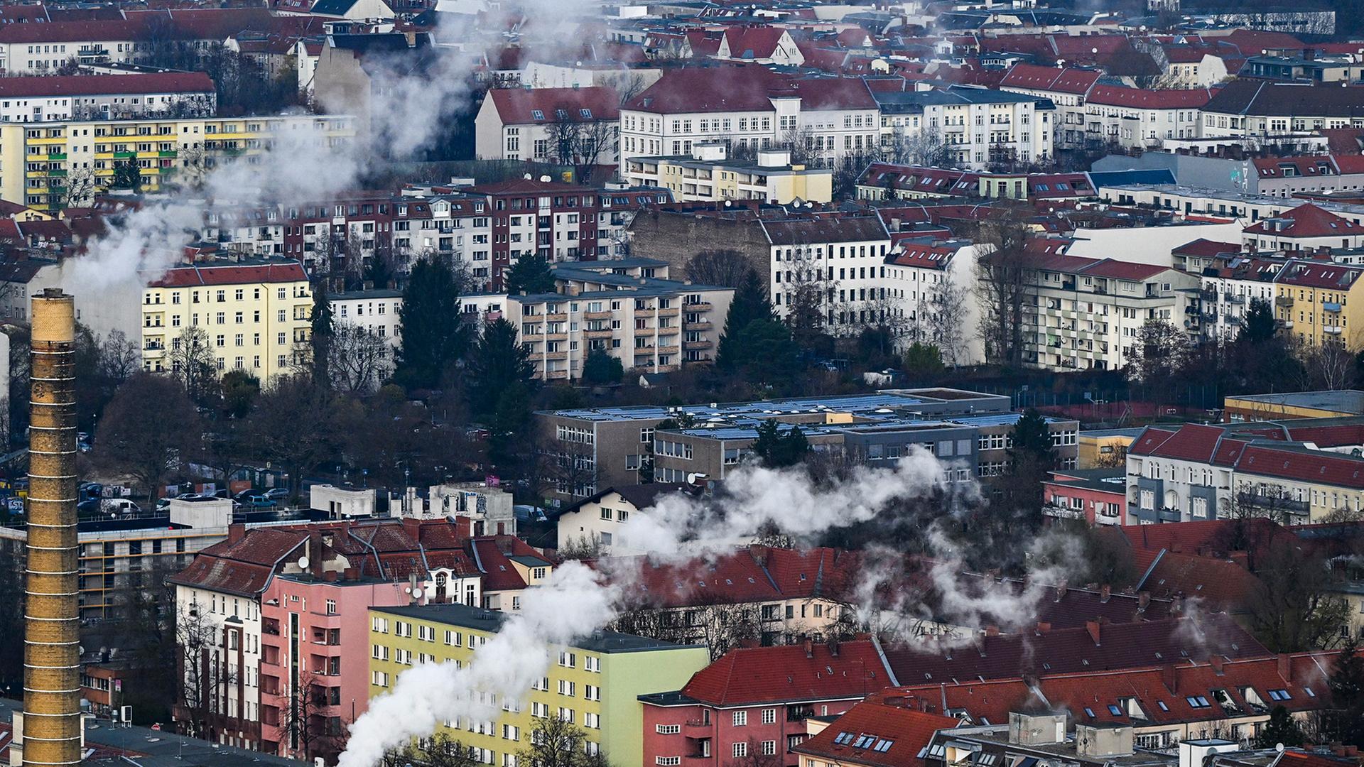 Wohnhäuser in Berlin im Winter, aus deren Schornsteinen Rauch aufsteigt. | dpa