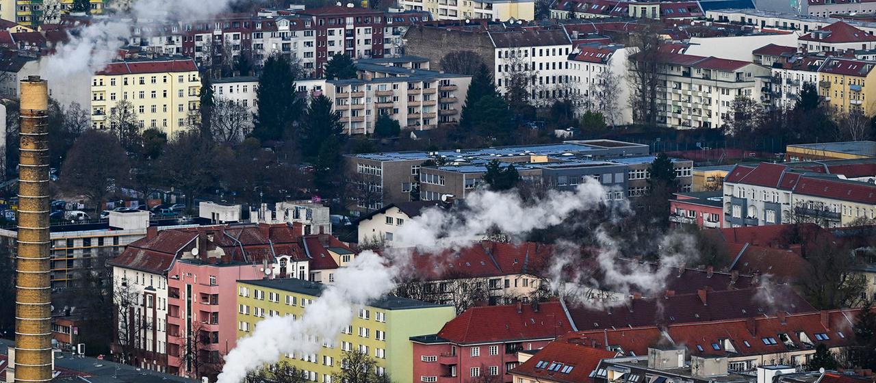  Rauch kommt aus Schornsteinen vom FHW Neukölln und steigt über Wohnhäusern auf.