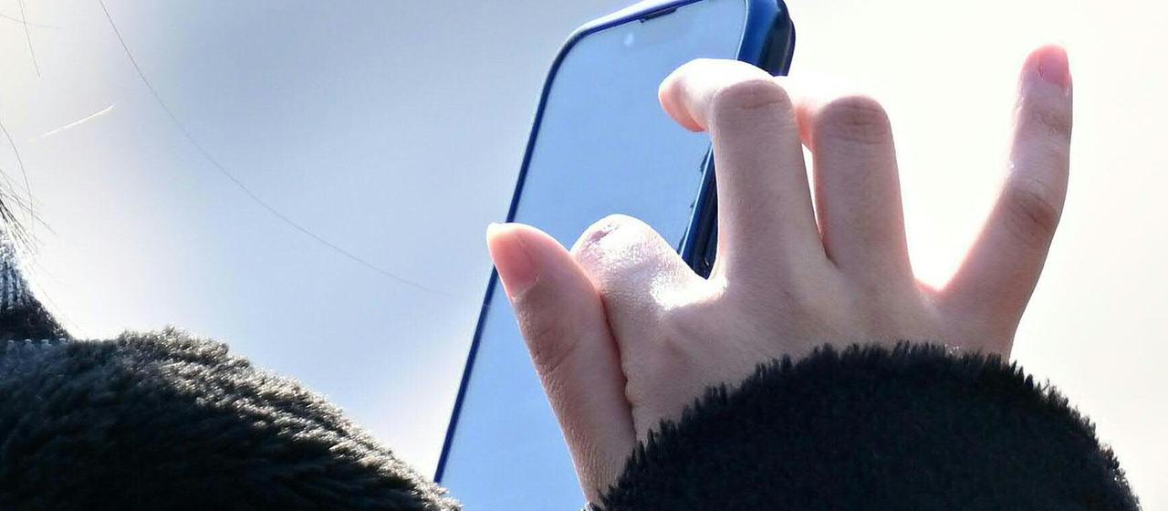 Eine Frau hält ein Smartphone in der Hand.