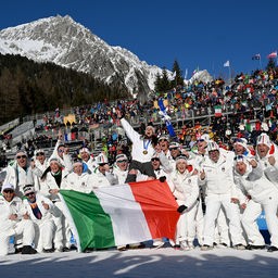 Lisa Vittozzi feiert den Gewinn einer Goldmedaille mit ihrem Team.
